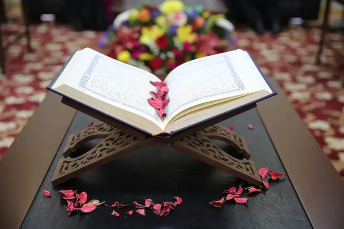 opened Quran Karim in a wooden Maqra'ah